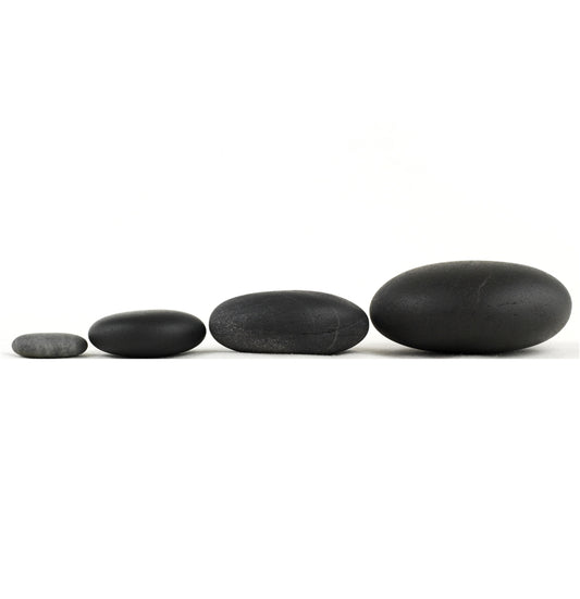 Authentic Basalt Stones. Four rounded black stones lined up from small to large.